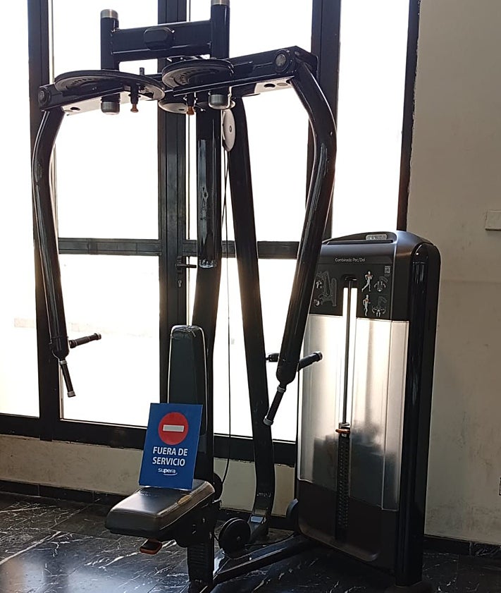 Imagen secundaria 2 - Acceso al polideportivo de Abastos y una de las máquinas que están fuera de servicio.