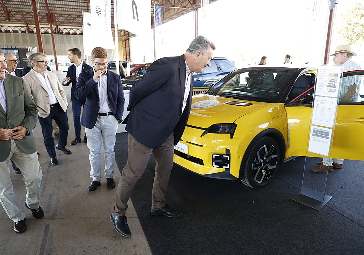 El conseller observa uno de los vehículos eléctricos de la Feria.
