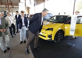 El conseller observa uno de los vehículos eléctricos de la Feria.