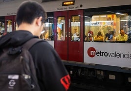 Un joven espera un metro en la estación.