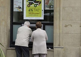 Dos mayores manipulan un cajero automático exterior, en una imagen de archivo.