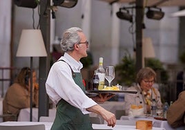 Un camarero se dispone a llevar la comanda a una mesa.