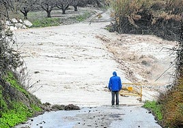 Un hombre contempla una carretera cortada por la lluvia, en una imagen de archivo.