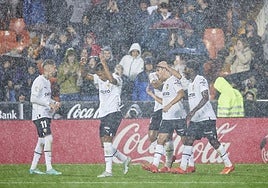El Valencia, jugando bajo la lluvia en Mestalla, en una imagen de archivo.