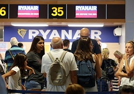 Viajeros en el aeropuerto de Manises frente a la zona de embarque de Ryanair.