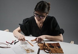 Empar Hoyo, en su mesa trabajando con uno de los abanicos de su firma.