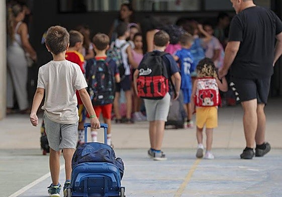 Niños entrando a un colegio al inicio del curso escolar.