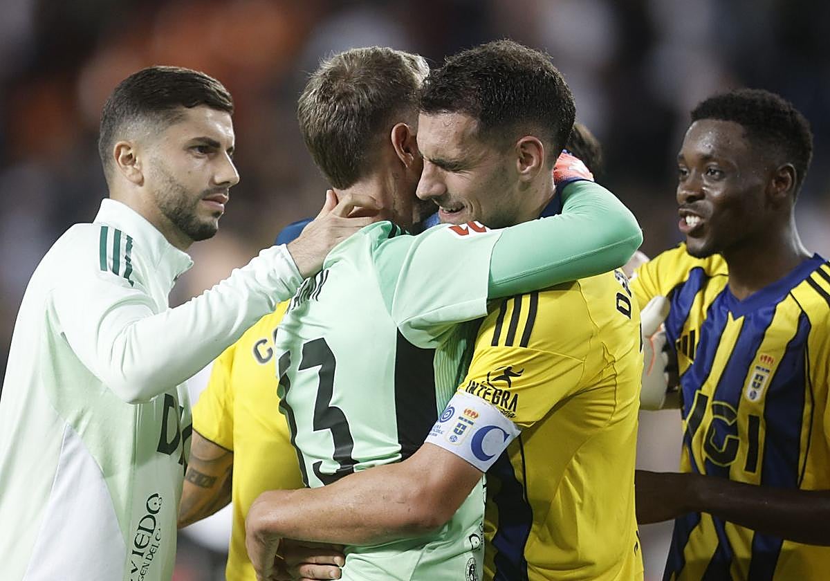 Aarón Escandell, siendo abrazado por sus compañeros del Oviedo en Mestalla.