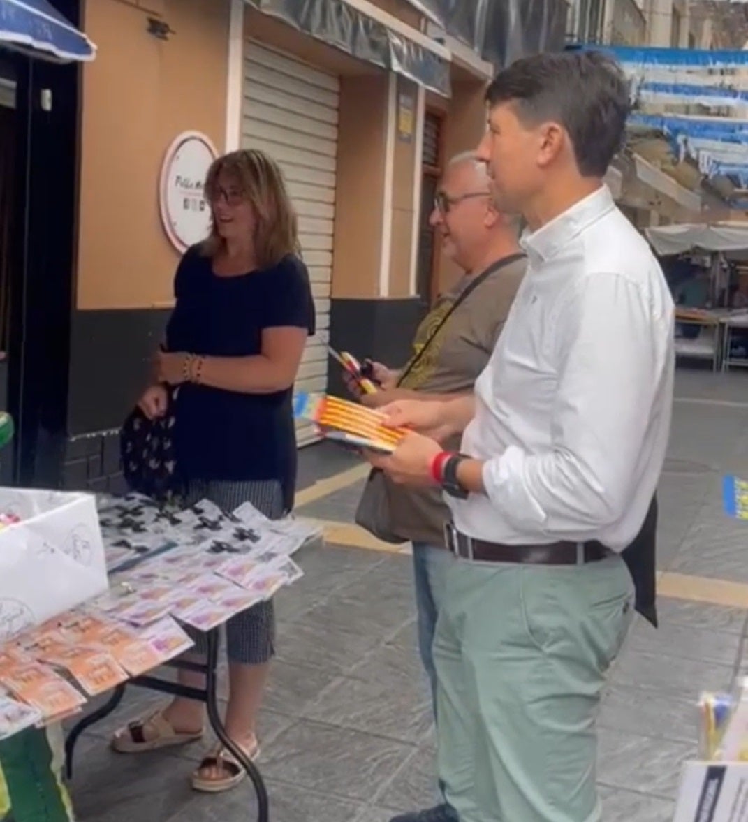 El portavoz del PP en el Ayuntamiento de Xàtiva repartiendo senyeras.
