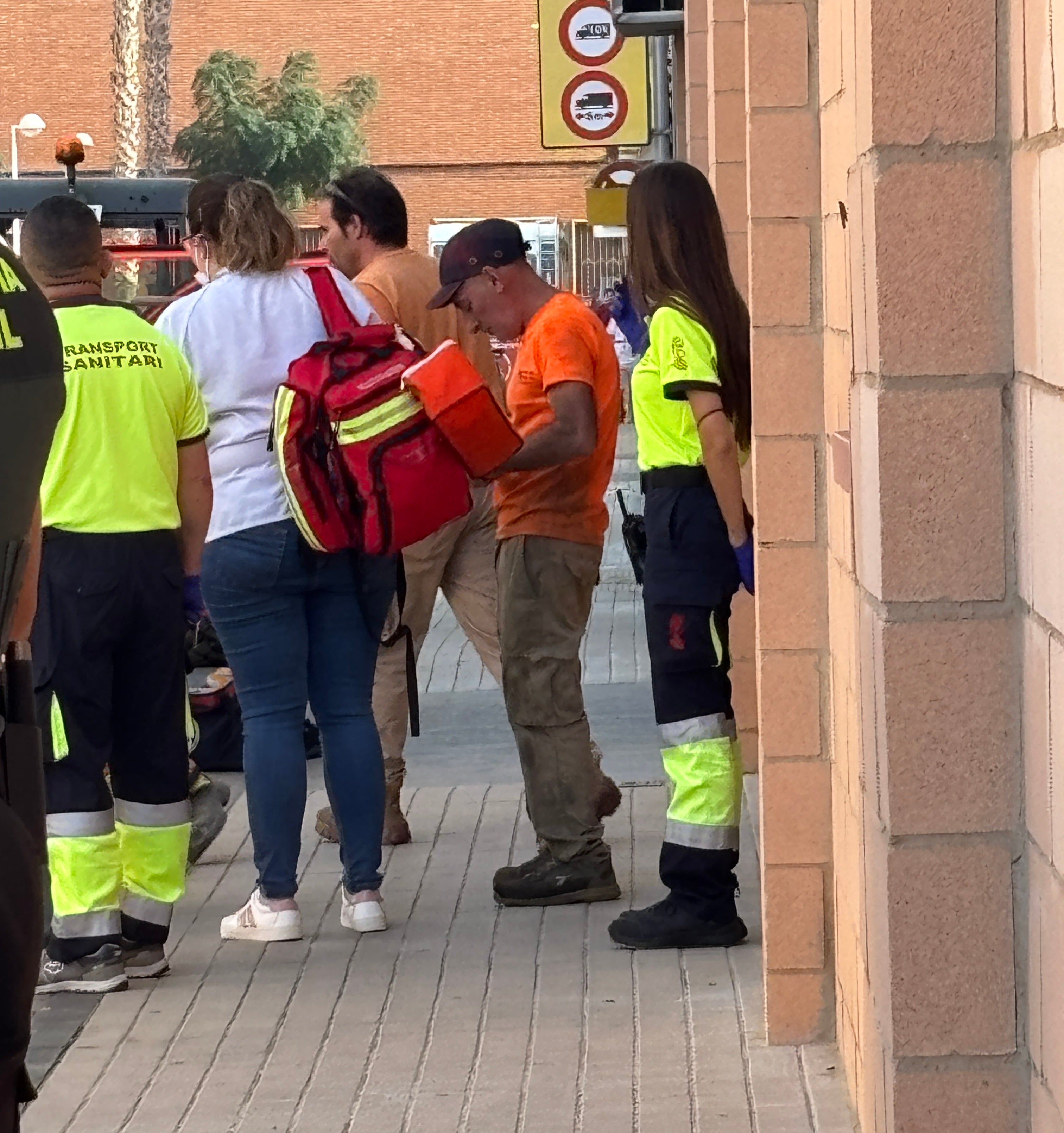 Uno de los trabajadores que limpiaban la nave, de naranja, entre los sanitarios desplazados.