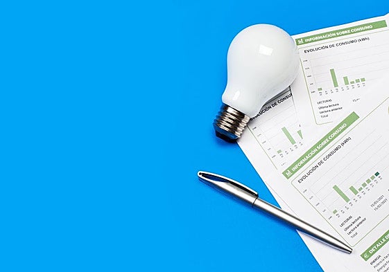 Una factura de la luz junto a una bombilla.