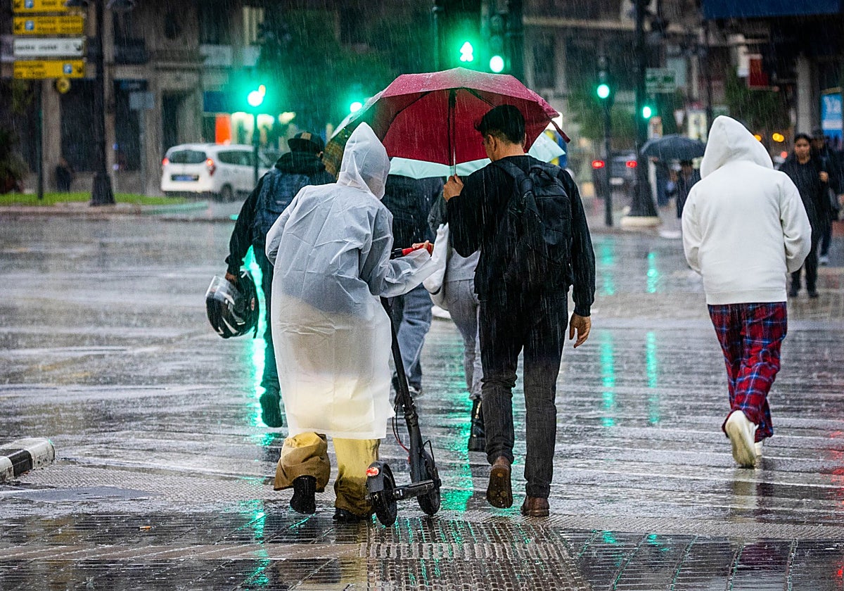 Un grupo de personas caminan bajo la lluvia en Valencia.