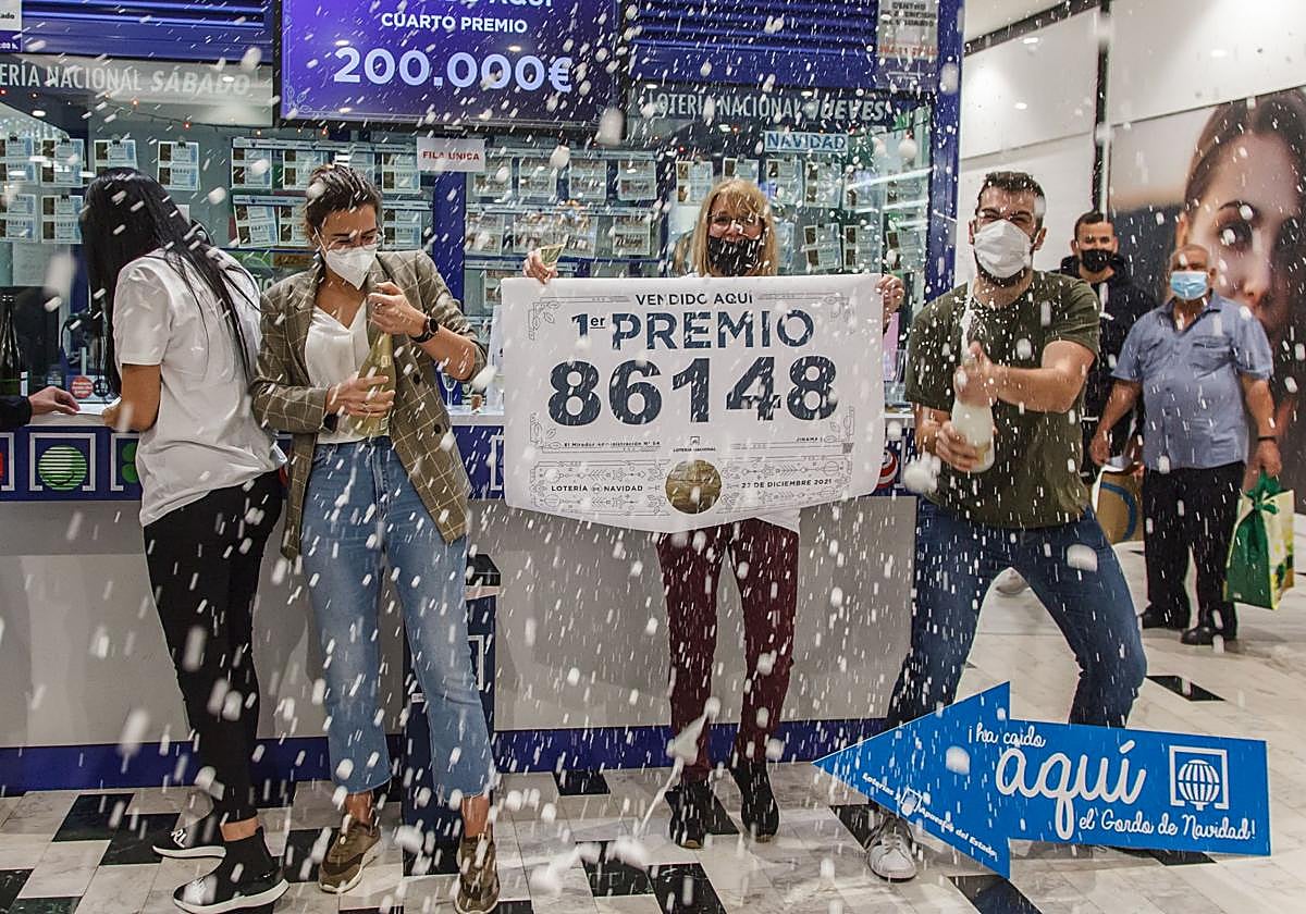 Varios agraciados celebran un premio de lotería en una administración.