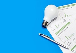 Factura de la luz junto a una bombilla y un boligrafo