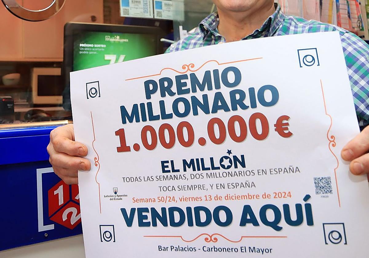 Vendedor de lotería posa con el boleto ganador.