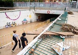 Dos vecinas cruzan el paso inundable lleno de barro en Aldaia, el 12 de octubre de 2025.