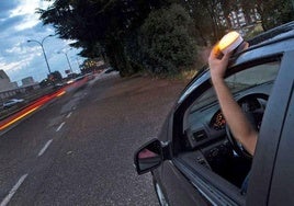Un conductor coloca una baliza V16 en la parte superior del vehículo.