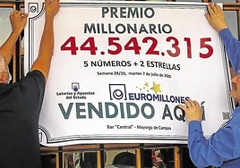 Dos de los afortunados ganadores del Euromilones cuelgan el cartel, en una imagen de archivo.