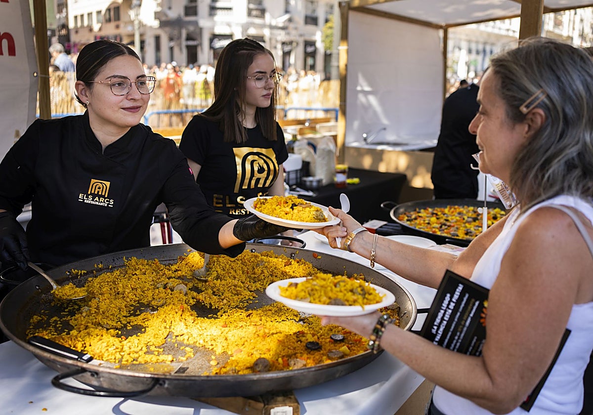 Una mujer recibe su ración en un momento del certamen gastronómico, este domingo, en Valencia.