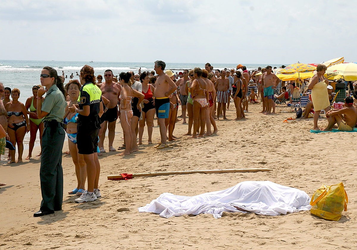 Varias personas llenan una playa de Guardamar junto al cuerpo sin vida de una persona ahogada, en una imagen de archivo.
