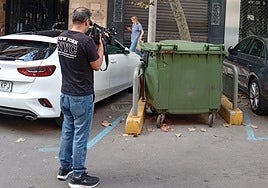 Un periodista graba un contenedor en la calle de Castellón donde ocurrió el trágico suceso.