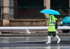 Un hombre pasea bajo la lluvia en Valencia.