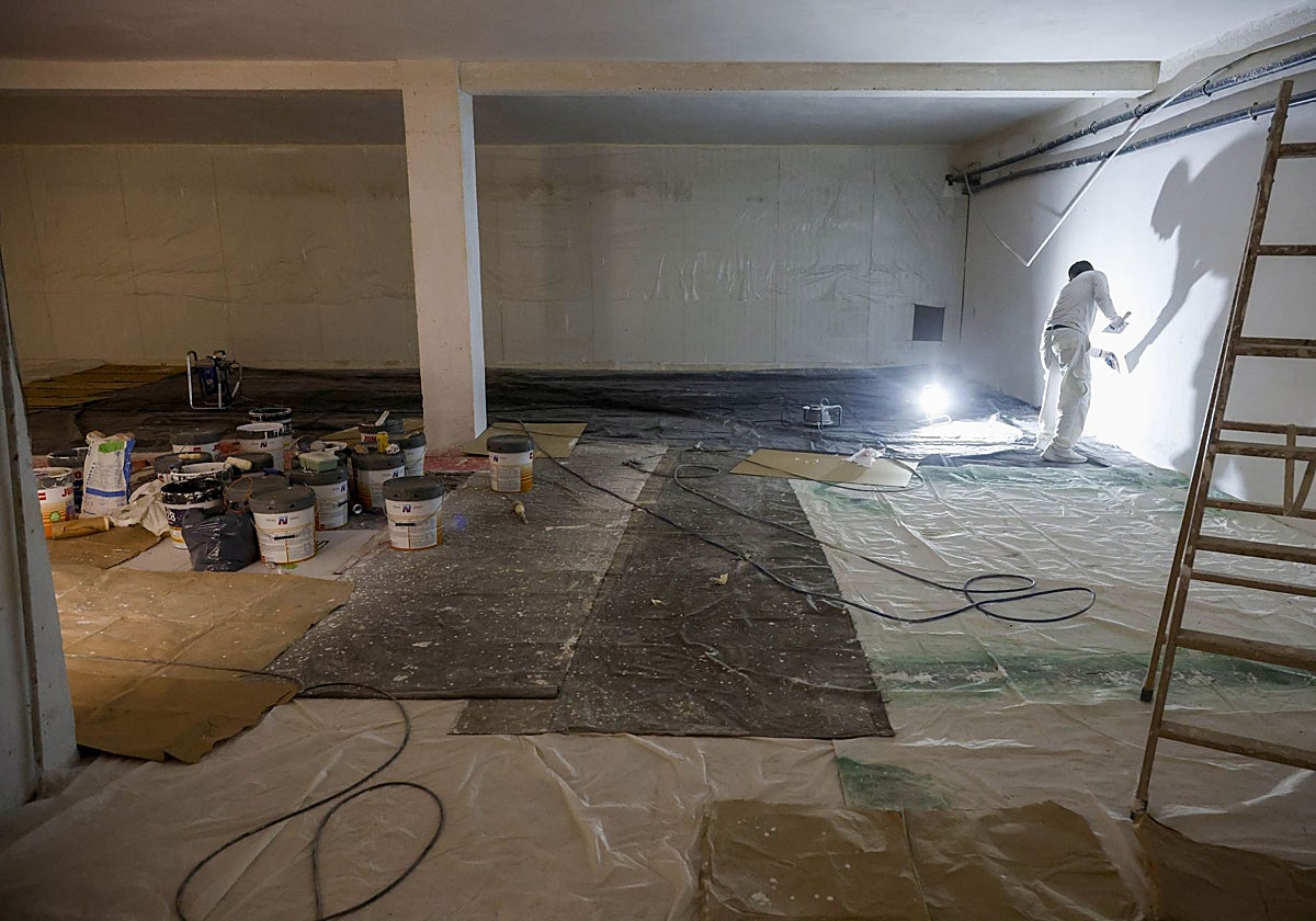 Un pintor trabaja en el interior de una nave arrasada en Paiporta.