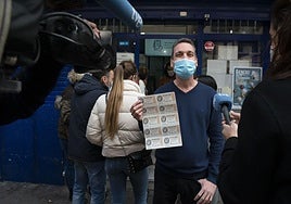 Un ganador posa con su boleto premiado de lotería. Imagen de archivo.