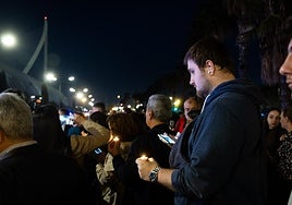 Manifestantes sostienen velas en honor de las víctimas junto a la Ciutat de les Arts.