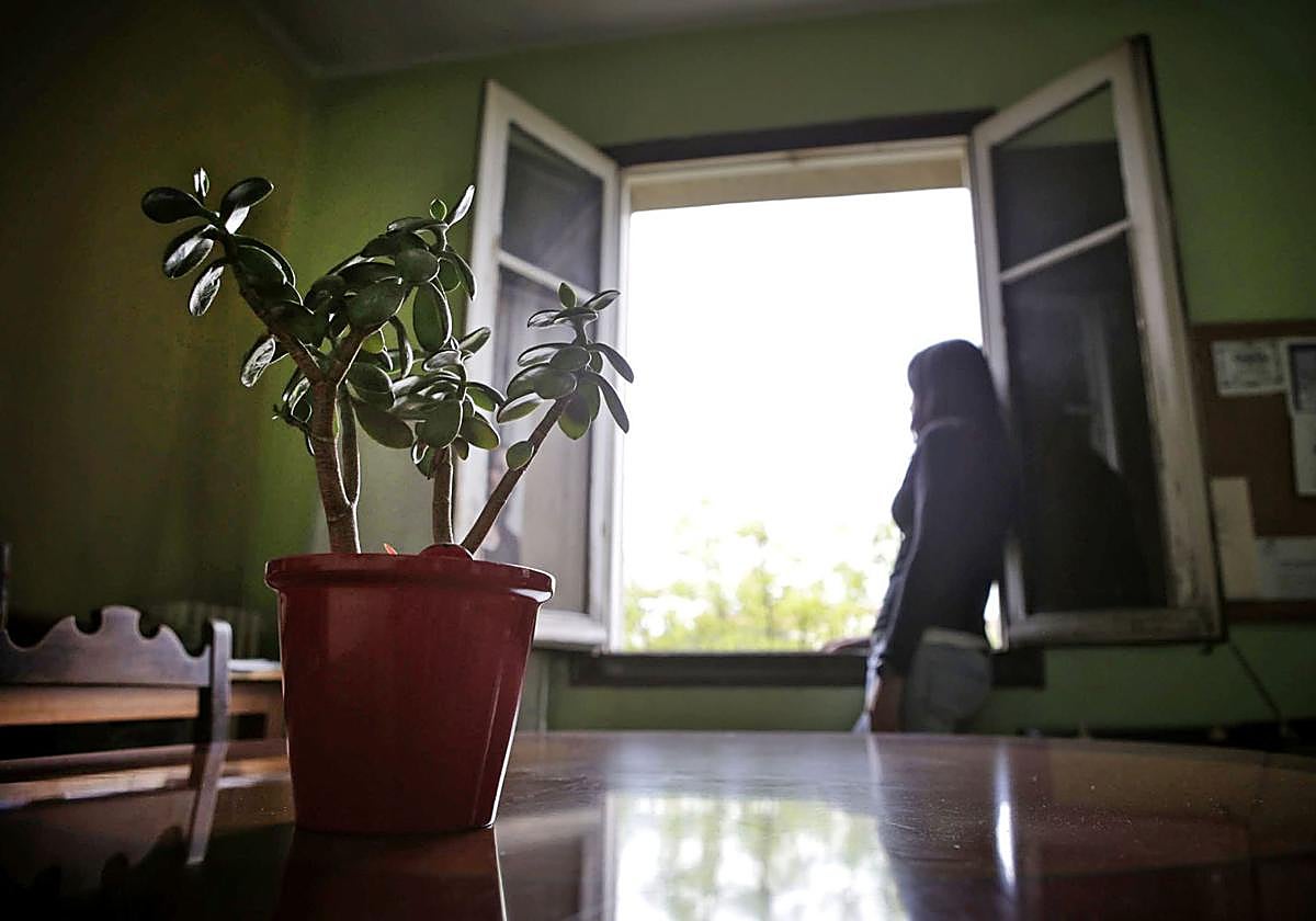 Una mujer mira por la ventana de su habitación en un centro de desintoxicación.