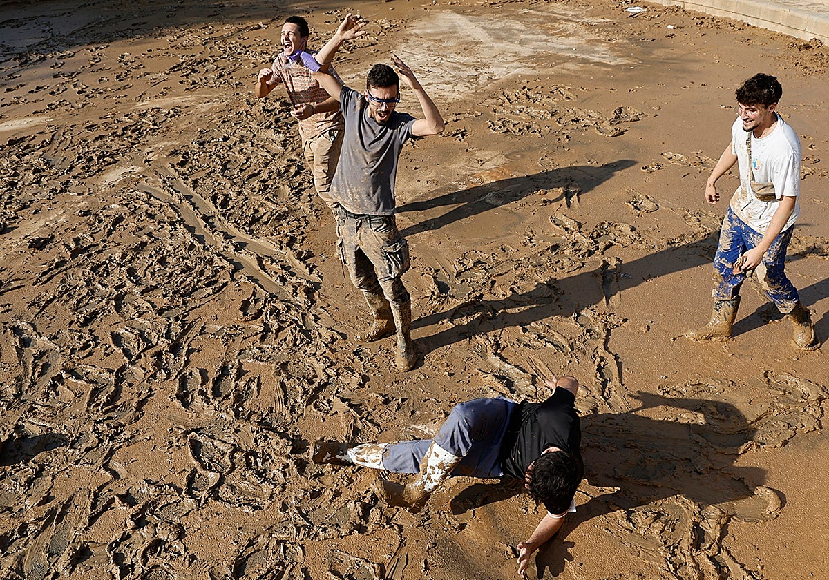 Unos jóvenes juegan en el barro en Alfafar días después de la dana.