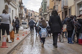Mujeres acompañando a sus hijos al colegio en Paiporta.