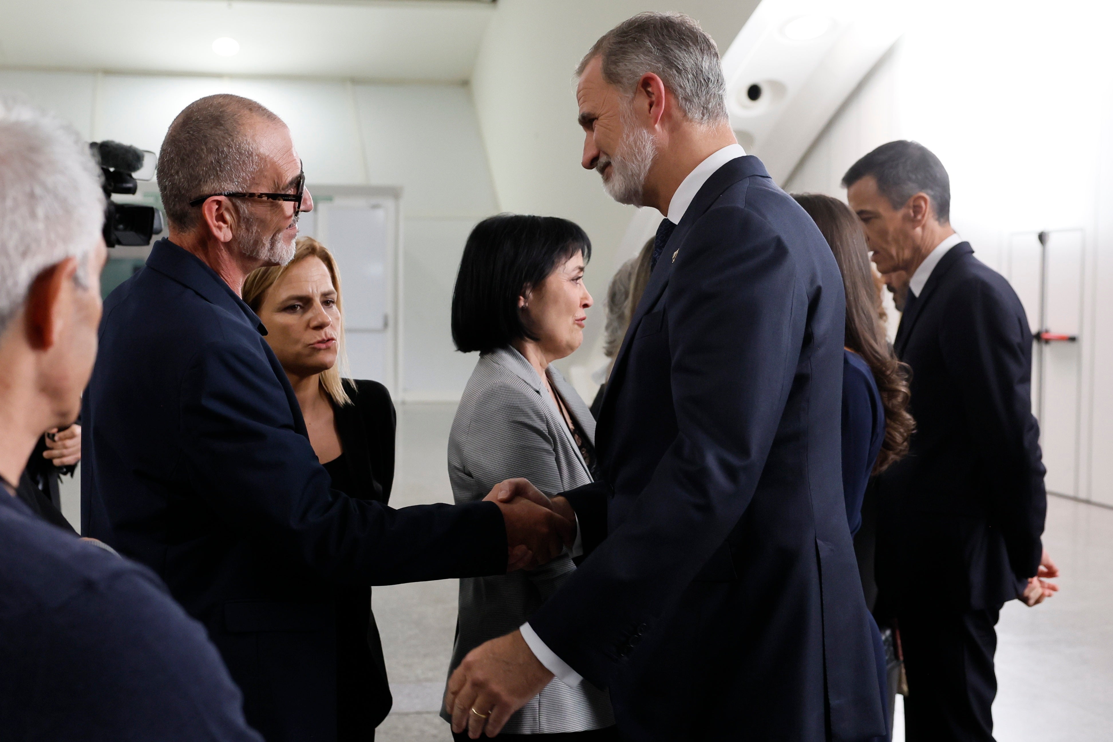 El Rey dialoga con una víctima durante el funeral de Estado en presencia de la delegada del Gobierno.