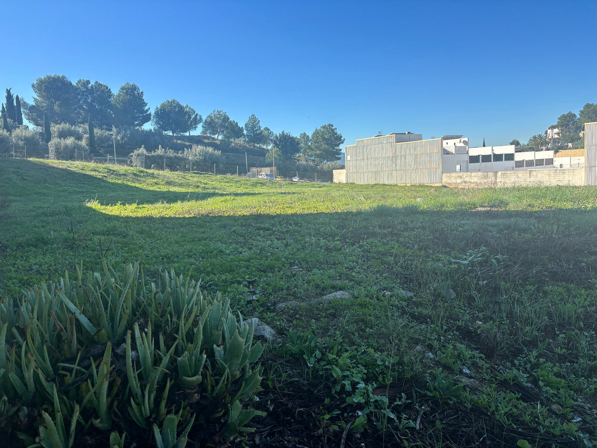 Arriba, solar donde se construirá el centro. Abajo, recreación de la parte ajardinada que tendrá el edificio.