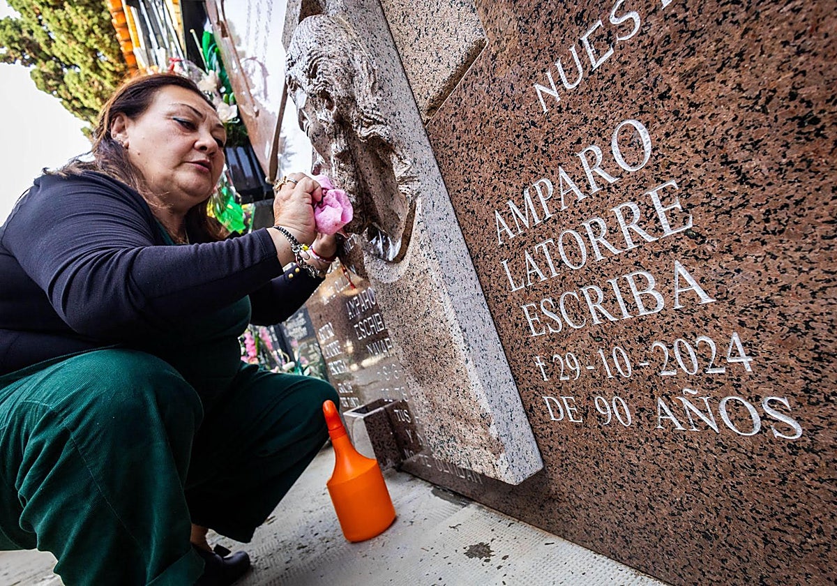 Amparo Aparisi limpia la lápida de su madre que falleció en la dana.