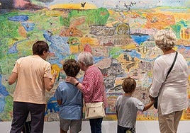 Nietos y abuelas miran una exposición.