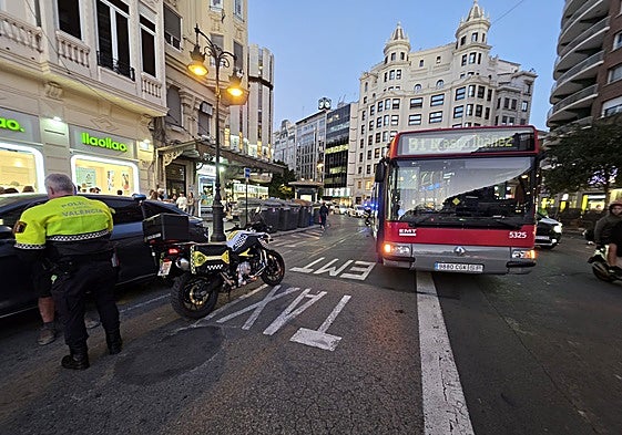 Un policía local junto al autobús de la EMT golpeado por el coche eléctrico.