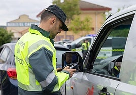 Un agente de Tráfico de la Guardia Civil comprueba la documentación de un conductor.