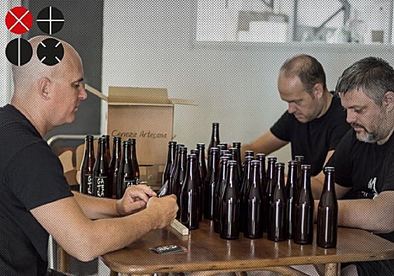 El proceso manual de etiquetado de las botellas de cerveza 'Gatera'.