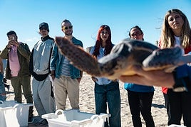 Los cantantes, durante la suelta de las tortugas en la playa de La Garrofera.