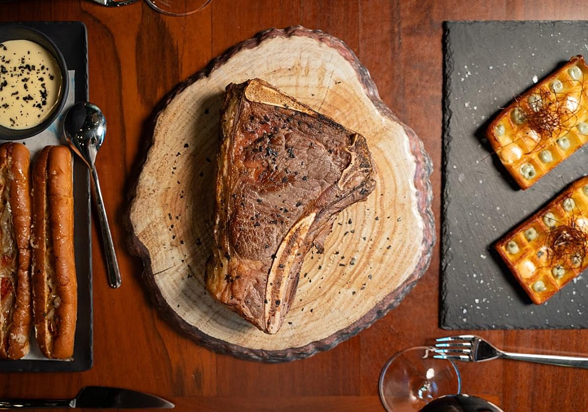 Chuletón de vaca madurada de un kilo con bonito frito, junto al gofre bravo.