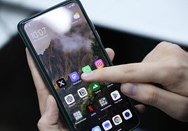 Un usuario consulta su teléfono móvil.