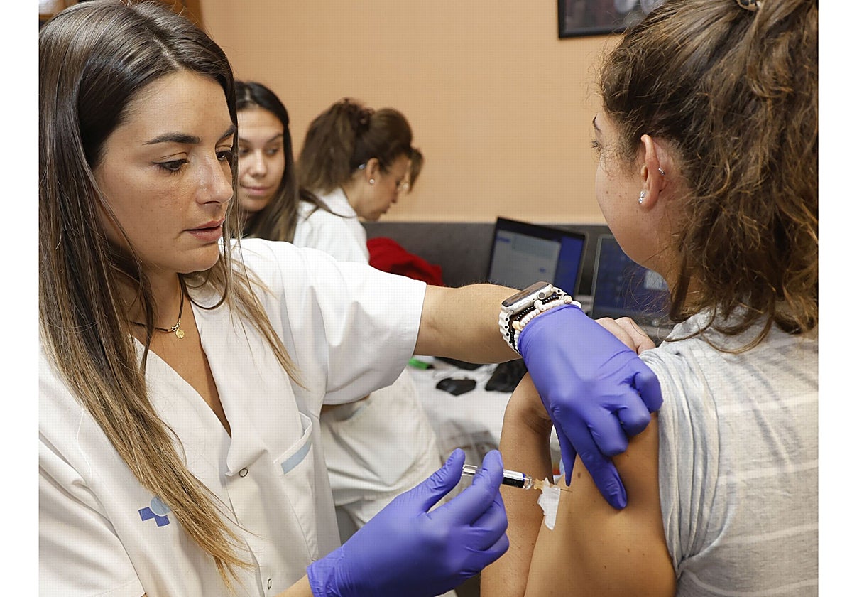 Una enfermera vacuna a una mujer en un centro de salud.