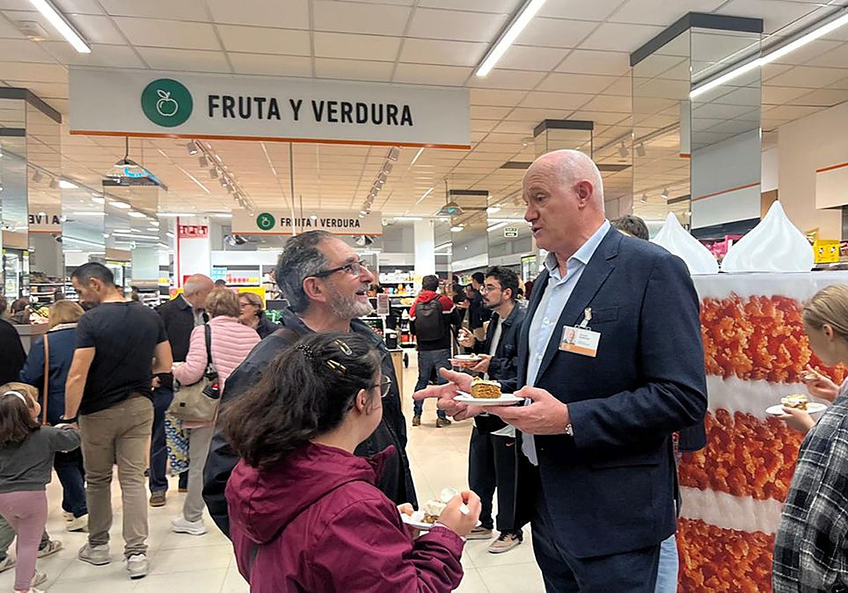 Antonio Rodríguez, director general de Consum, junto a dos clientes en un supermercado.