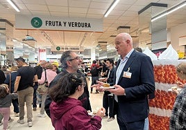 Antonio Rodríguez, director general de Consum, junto a dos clientes en un supermercado.