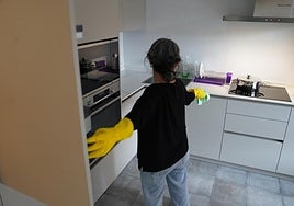 Una empleada del hogar realiza su trabajo en un domicilio.