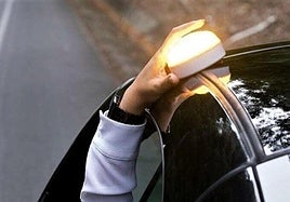 Una persona coloca la báliza V-16 en el coche.