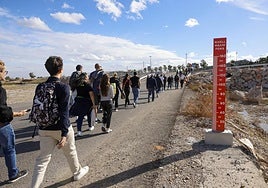 Personas cruzando el tramo del barranco del Poyo para llegar al Circuit Ricardo Tormo.