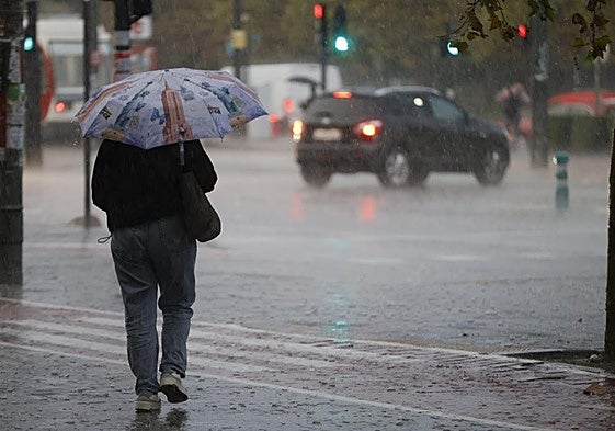 Una mujer camina bajo la lluvia en Valencia.