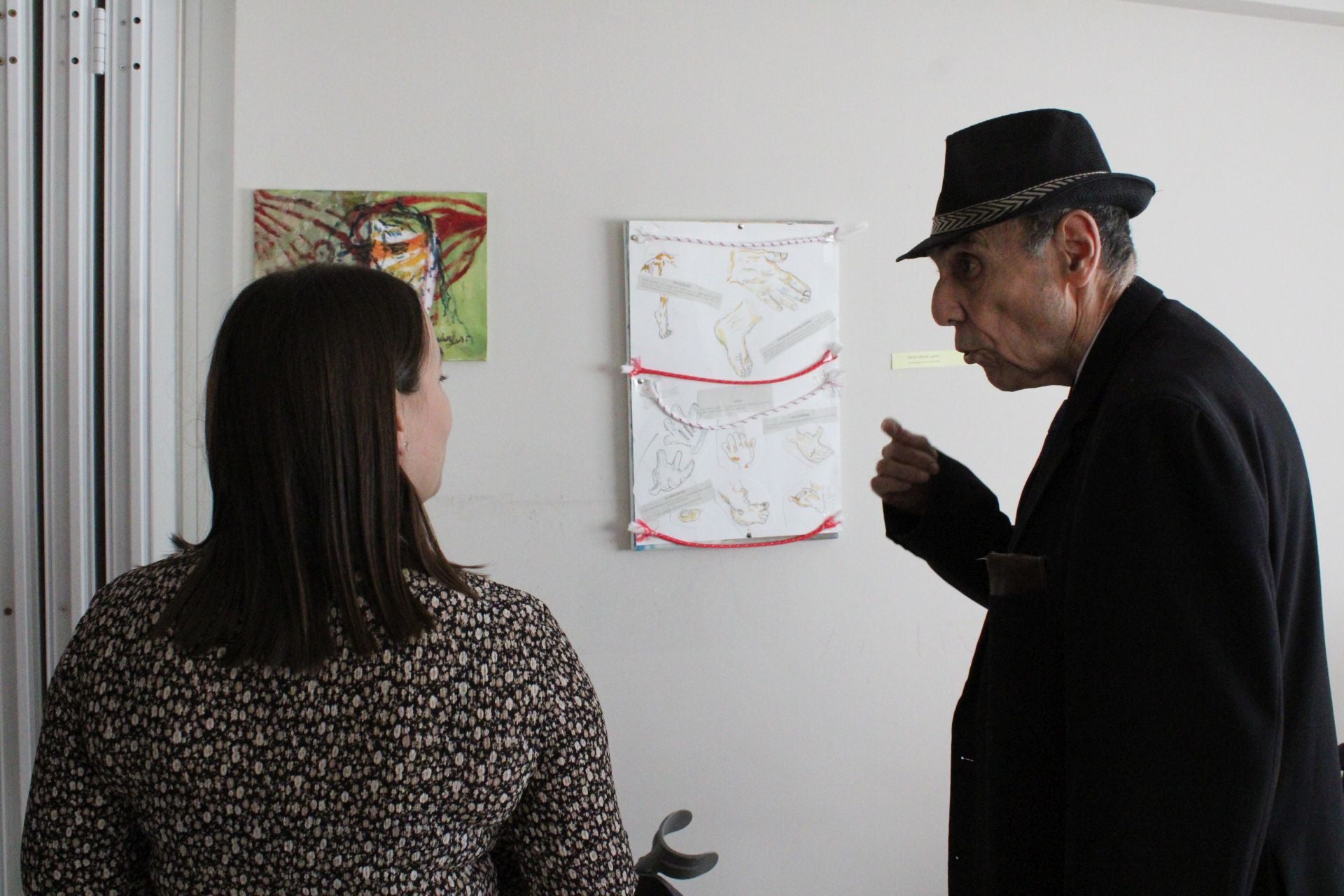 El artista explica una de sus obras a la edil de Servicios Sociales.